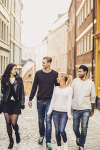 Multi ethnic friends walking on city street