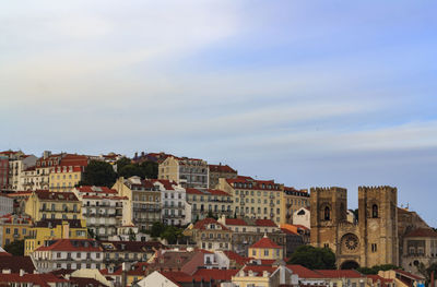 Buildings in city against cloudy sky