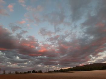 Scenic view of field against sky at sunset