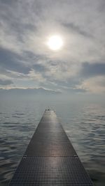 Surface level of pier against sky at sunset