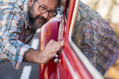 Man looking at red car