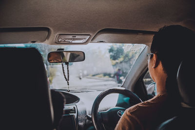 Rear view of man driving car