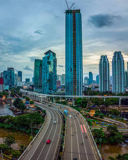 Road passing through city against sky