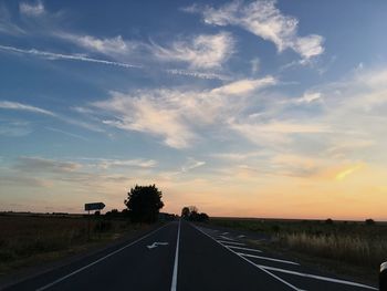 Empty road against sky during sunset