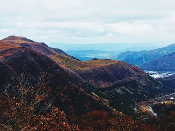 Scenic view of mountain range against cloudy sky