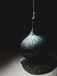 Close-up of electric lamp on table against black background