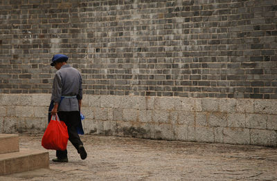 Man wearing hat against brick wall