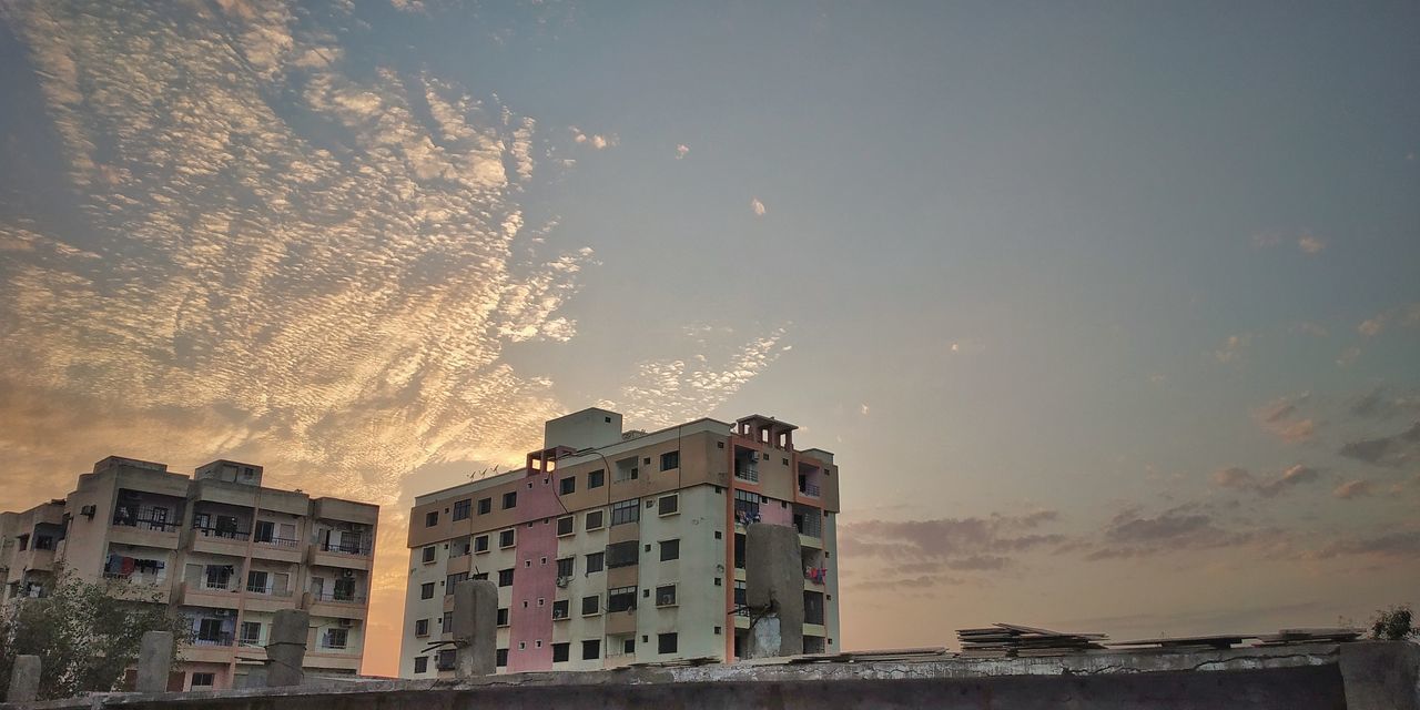 LOW ANGLE VIEW OF RESIDENTIAL BUILDINGS AGAINST SKY DURING SUNSET