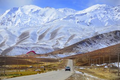 Road leading towards snowcapped mountains