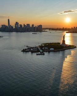 Scenic view of sea and buildings against sky during sunset