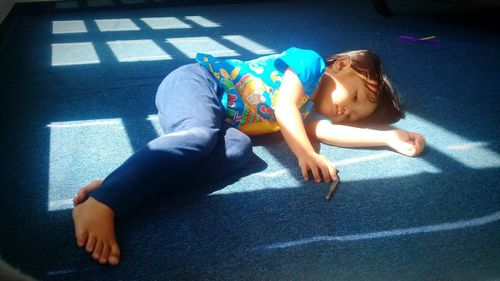 High angle view of girl lying down on floor