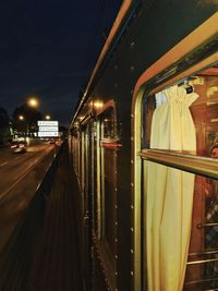 Train in illuminated city against sky at night