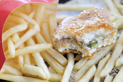 Close-up of half-eaten burger and fries on plate