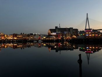 Reflection of buildings in city at waterfront