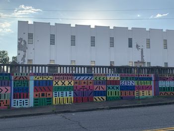 Graffiti on building against sky in city