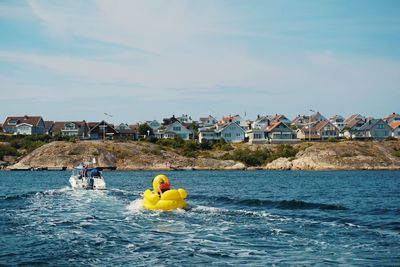 People enjoying in sea against sky