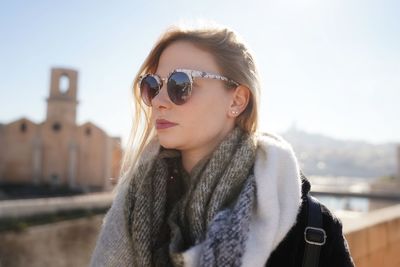 Young woman wearing sunglasses against clear sky