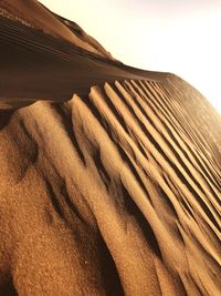 Sand dunes in desert against sky