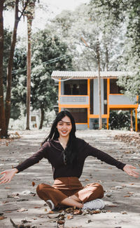 Portrait of smiling young woman sitting outdoors