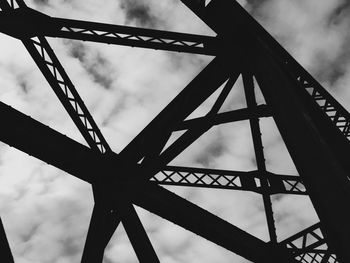 Low angle view of metal structure against cloudy sky