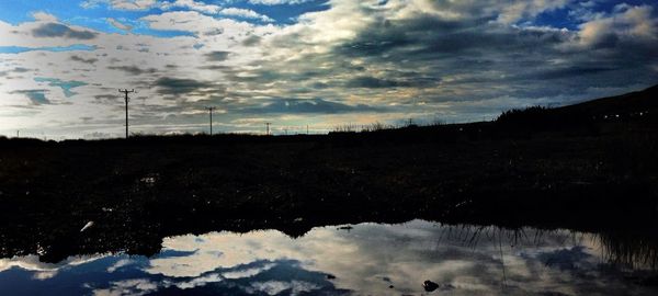 Scenic view of lake against cloudy sky