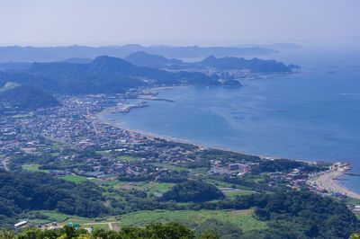 High angle view of city by sea against sky