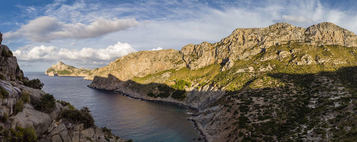 Scenic view of sea and mountains against sky