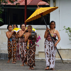 People walking with containers against building