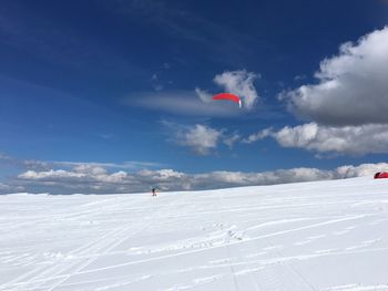 Person paragliding over mountain landscape