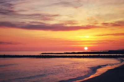 Scenic view of sea against romantic sky at sunset