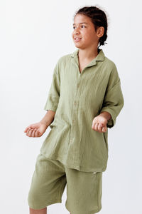 Portrait of young woman standing against white background