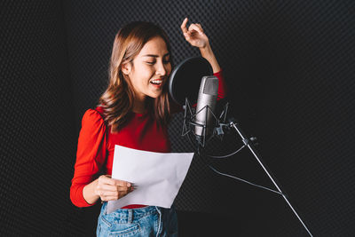 Woman singing at mic at studio