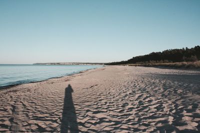 Scenic view of beach against clear blue sky