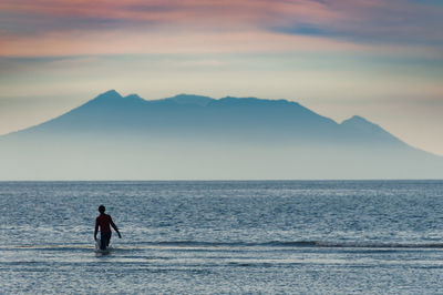 Rear view of silhouette man standing on beach