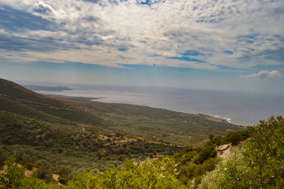 Scenic view of landscape by sea against sky