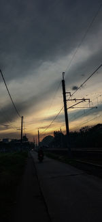 Cars on road against sky during sunset