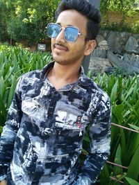 Portrait of young man wearing sunglasses standing outdoors