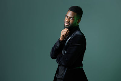 Young woman standing against black background