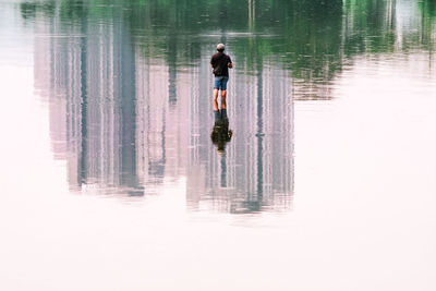 Rear view of man standing in lake