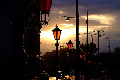 Street lights against orange sky