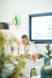 Female pottery artist making a vase in her home studio