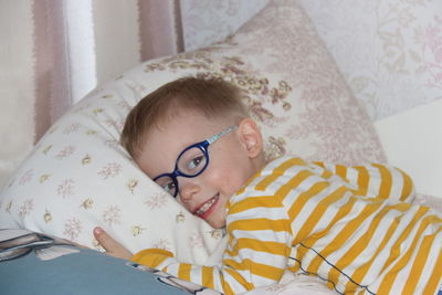 Portrait of cute boy resting on bed at home