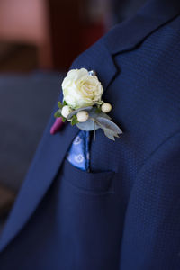 Close-up of white rose holding blue flower