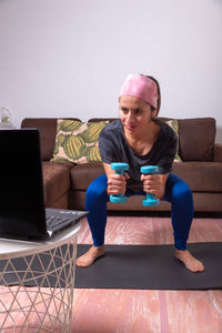 Portrait of young woman using laptop at home