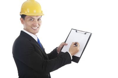 Portrait of man holding camera over white background