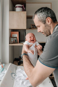 Dad getting his baby son ready for diaper change