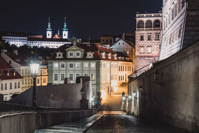 Street amidst buildings in city at night