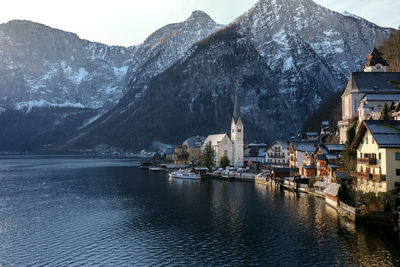 Panoramic view of lake and buildings in hallstatt against mountain during winter