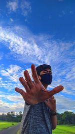 Midsection of man standing on field against sky