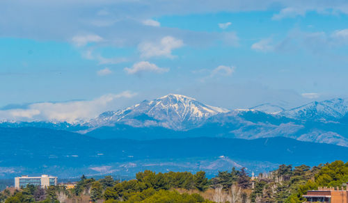 Scenic view of mountains and buildings against sky